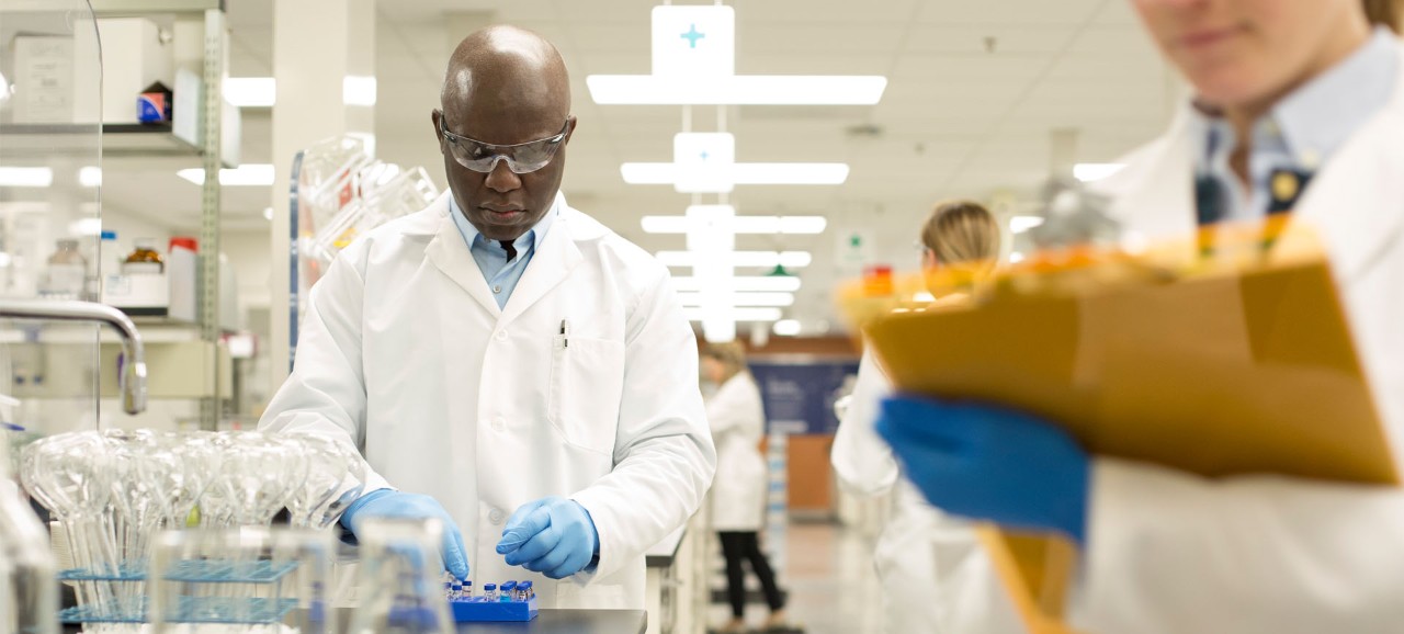 Black doctor in lab coat working on blood cancer pharmaceuticals